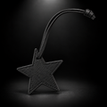 Black star bag charm on black spotlight background