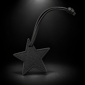 Black star bag charm on black spotlight background