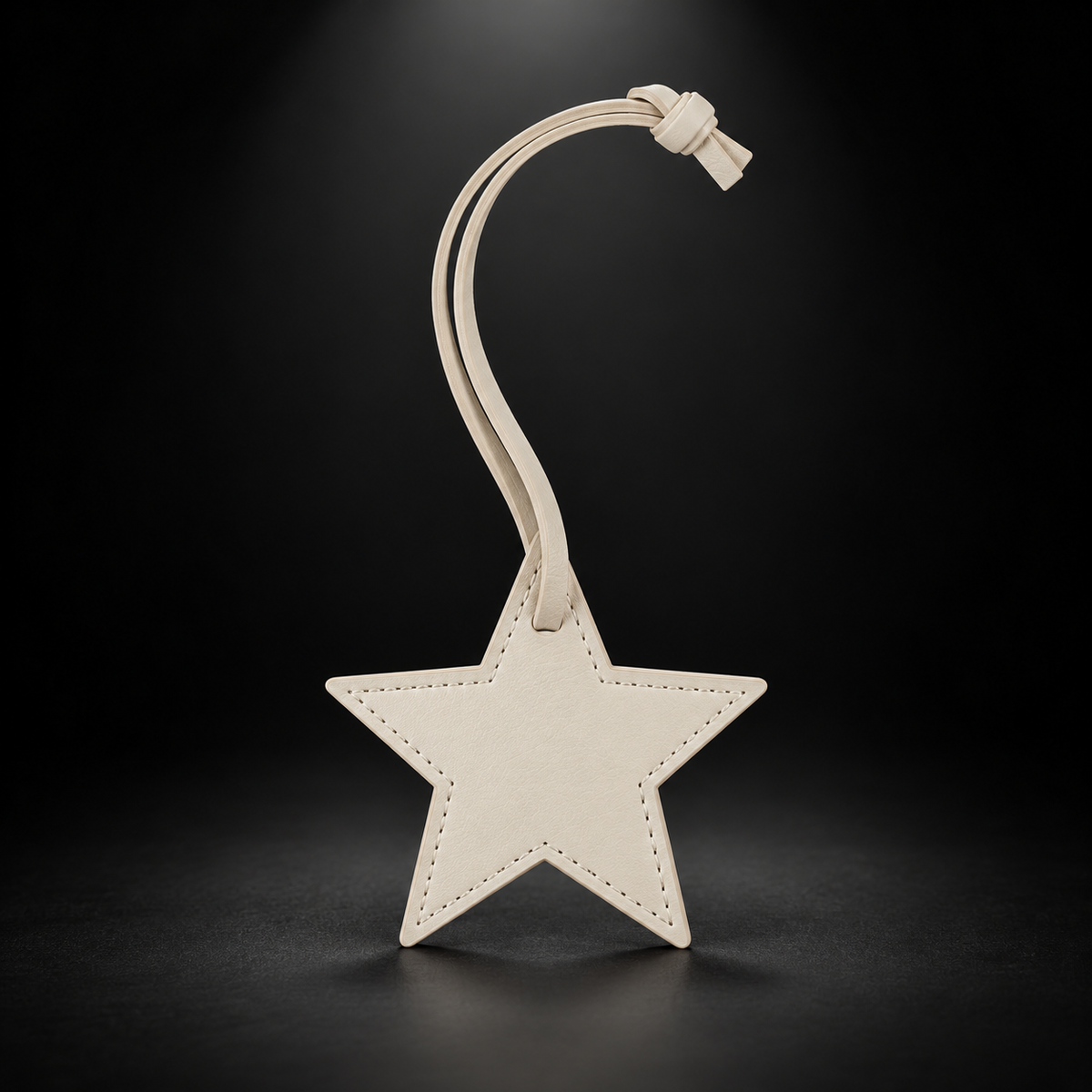 Ivory star bag charm on black spotlight background